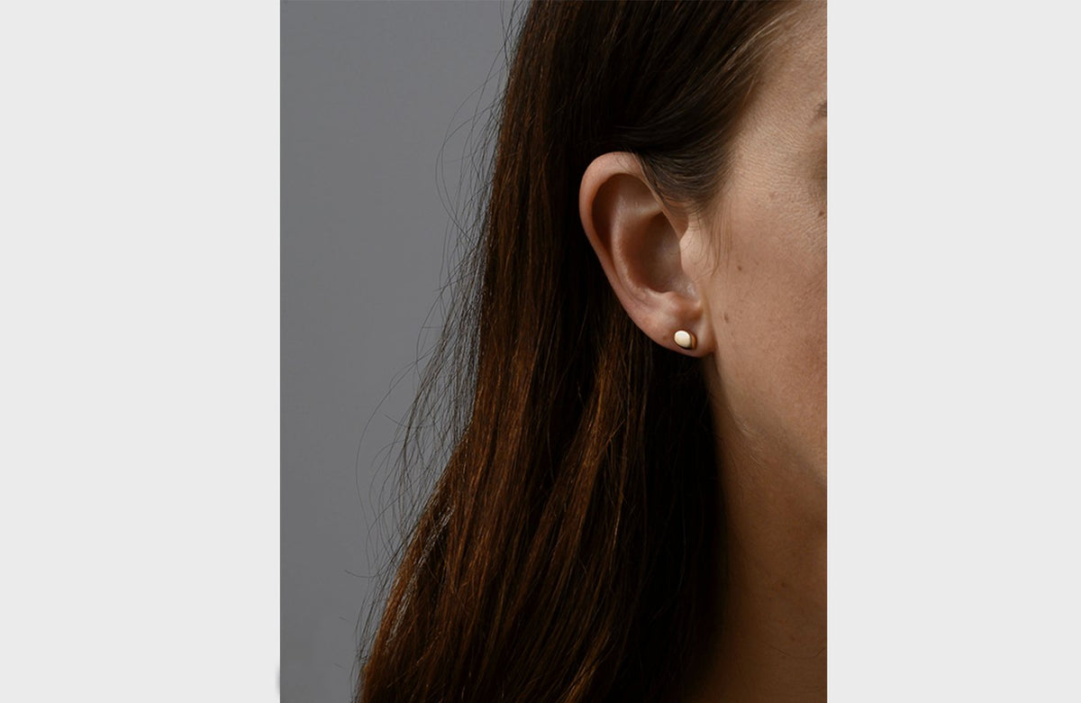 Woman Wearing Simple Gold Pebble Earrings