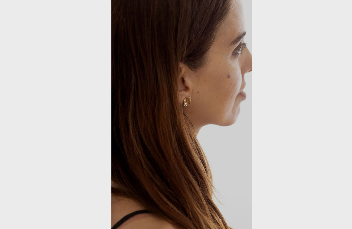 Woman Wearing Gold Wavy Earrings