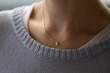 Woman Wearing Minimalist Gold and Diamond Necklace